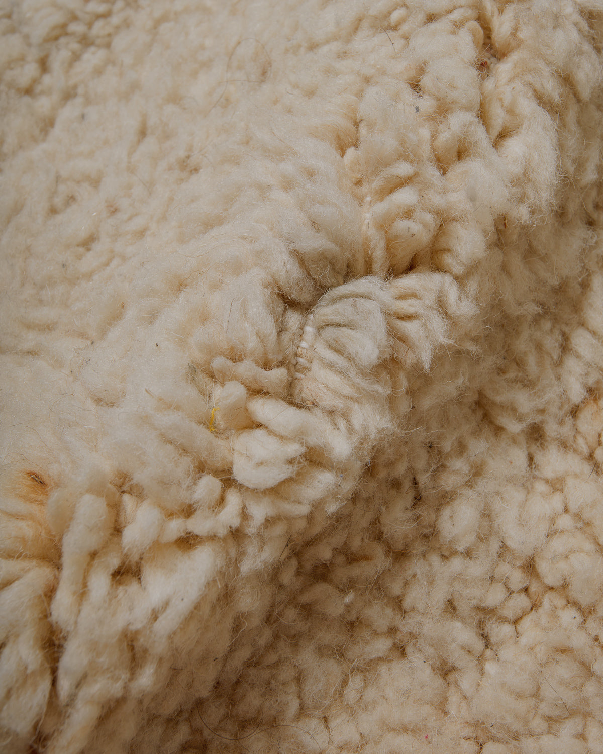 Close-up of cream wool rug showing very subtle darker area.